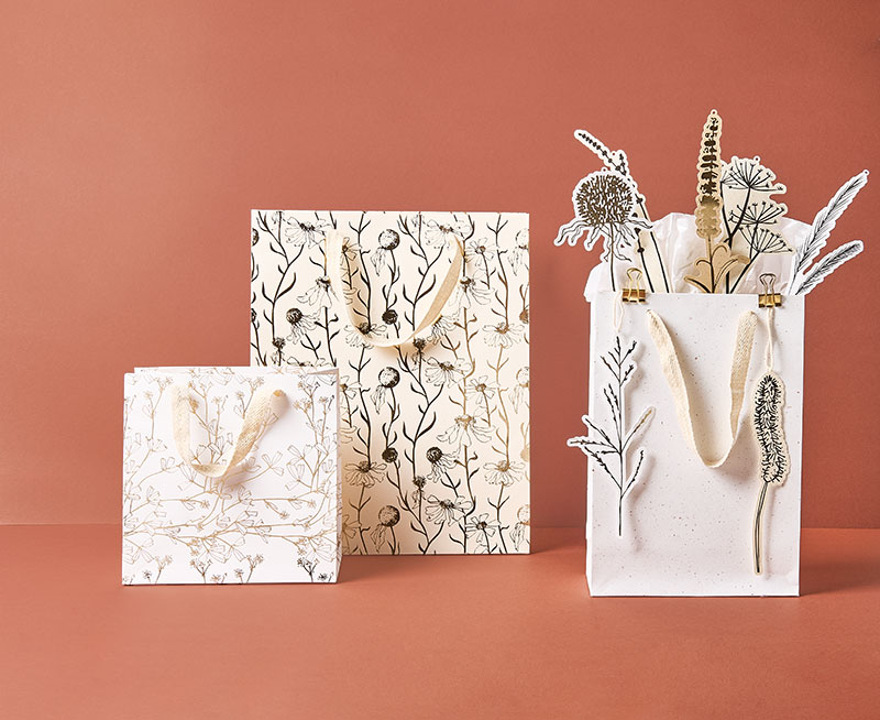 Drei Geschenktüten in unterschiedlichen Größen und Motiven, dazu verschiedene Geschenkanhänger. Produkte aus der Kollektion In The Meadow.