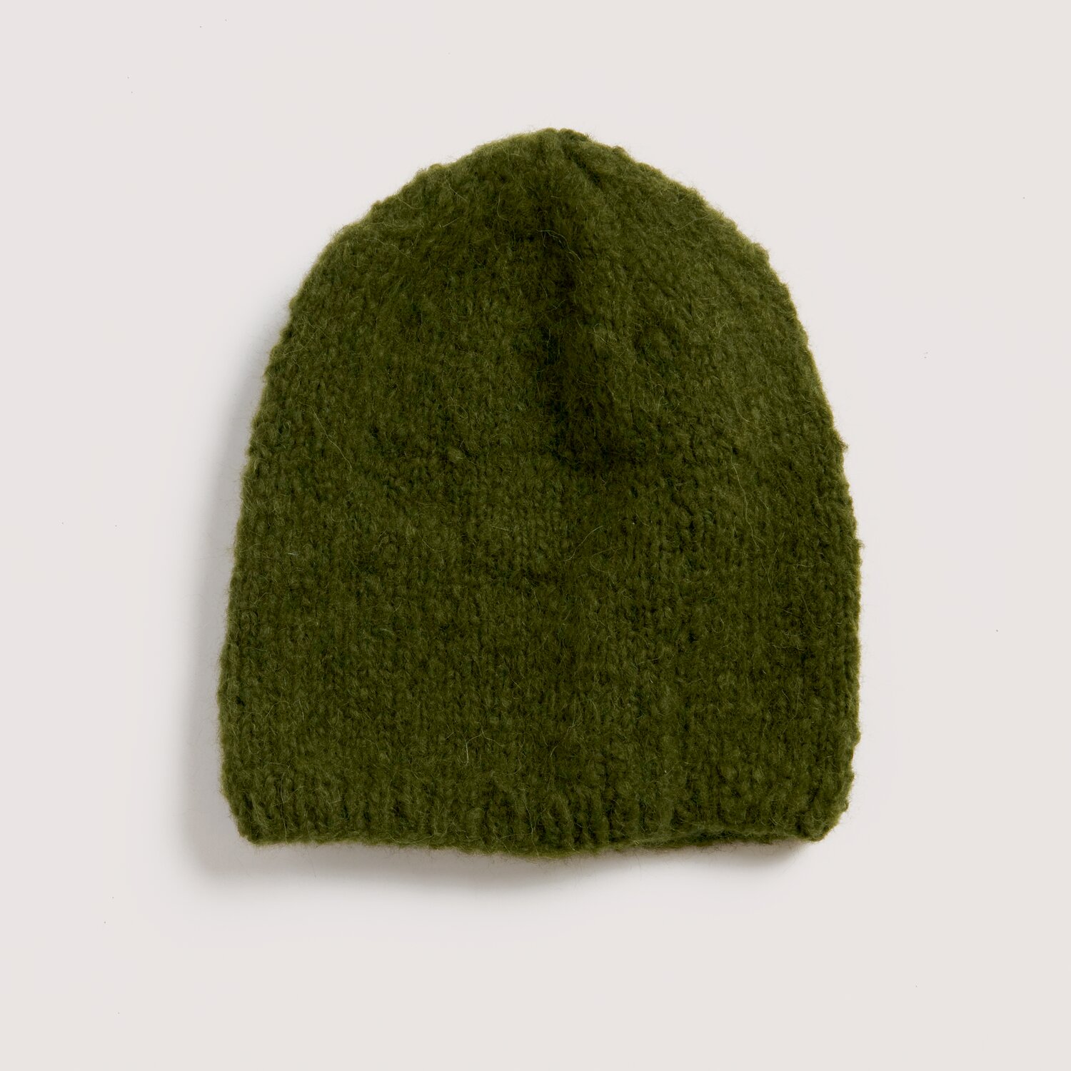 Strickset Mütze Modell 08 aus Luxury Knits Little Pieces, weiche Beanie aus moosgrünem, leicht flauschigem Strickgarn, flach auf hellem Hintergrund präsentiert