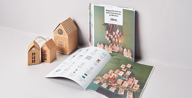 Prospekt Titel und aufgeschlagen, Adventskalender Häuser stehen daneben