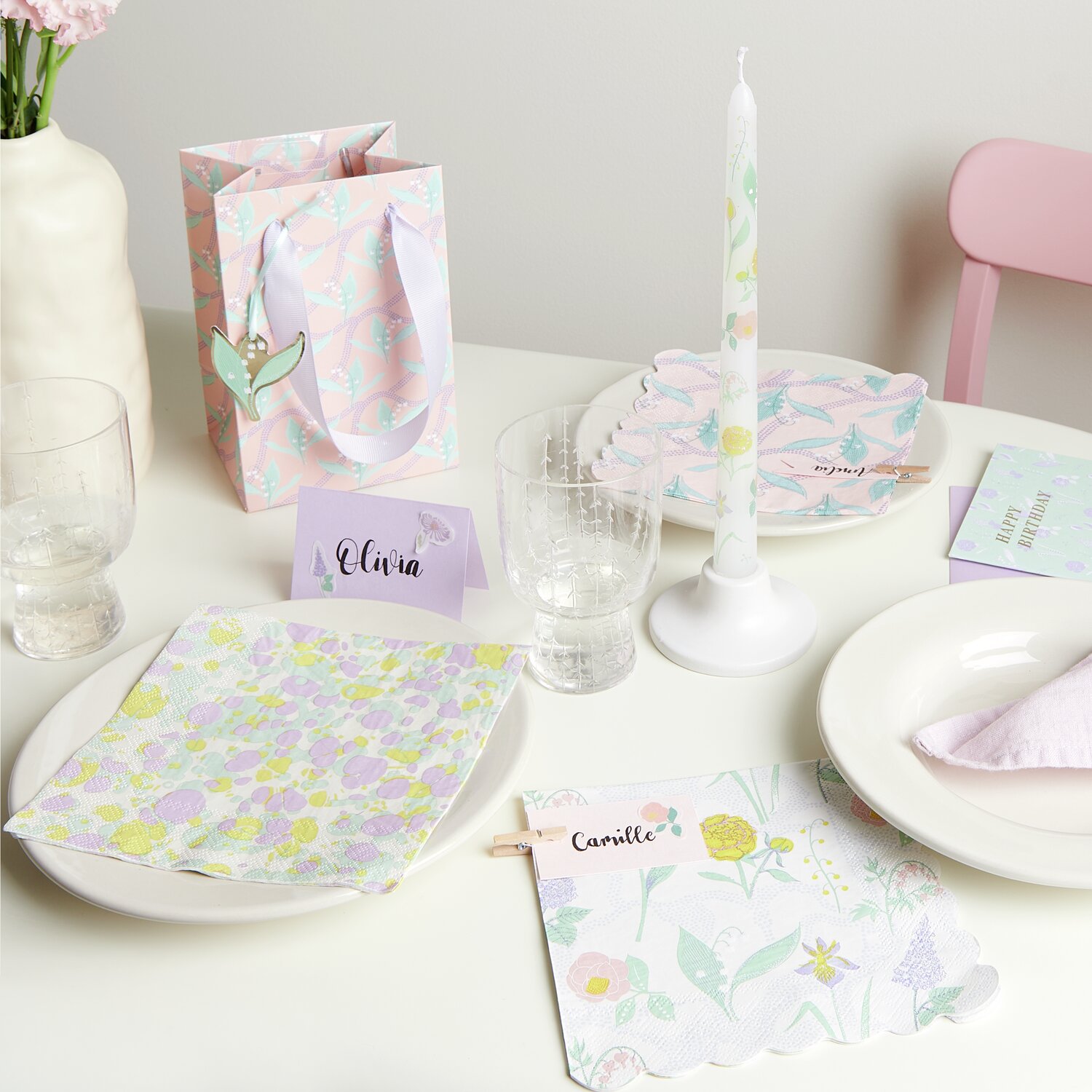 Servietten Blumenwiese 20 Stück auf einem gedeckten Tisch mit pastellfarbenen Dekorationen und Kerze. Ideal für frühlingshafte Anlässe.