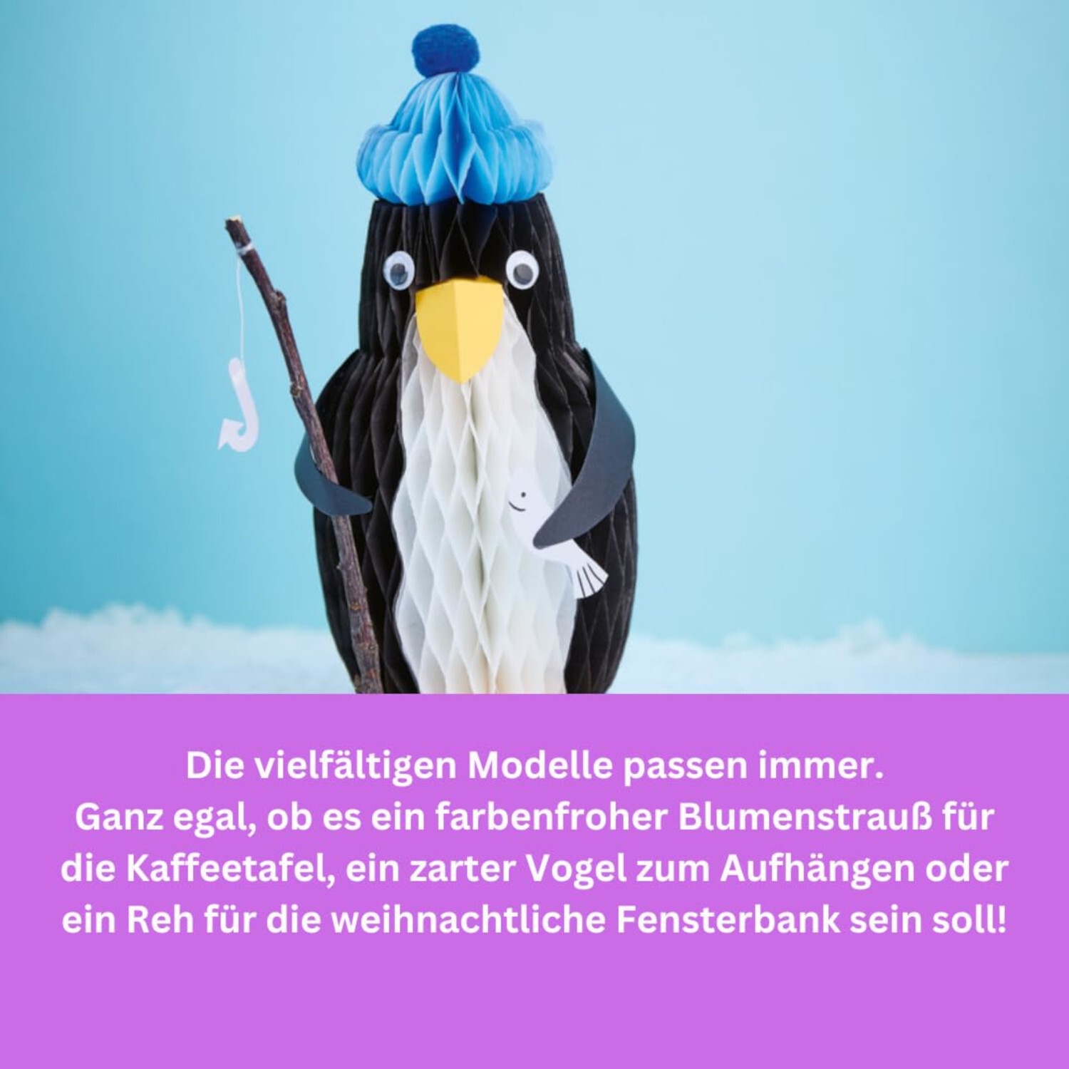 Filigrane Deko aus Wabenpapier: Pinguin mit blauer Mütze und Angel auf blauem Hintergrund.