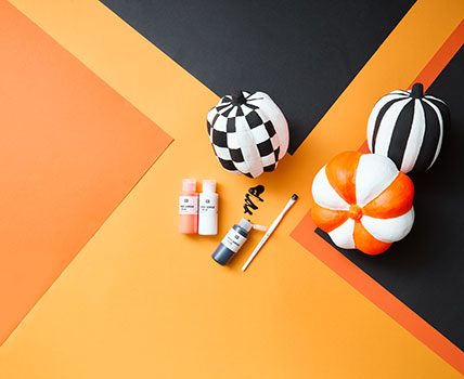 Pappkürbisse graftisch gestaltet mit schwarzer, weißer und orangefarbener Acrylfarbe