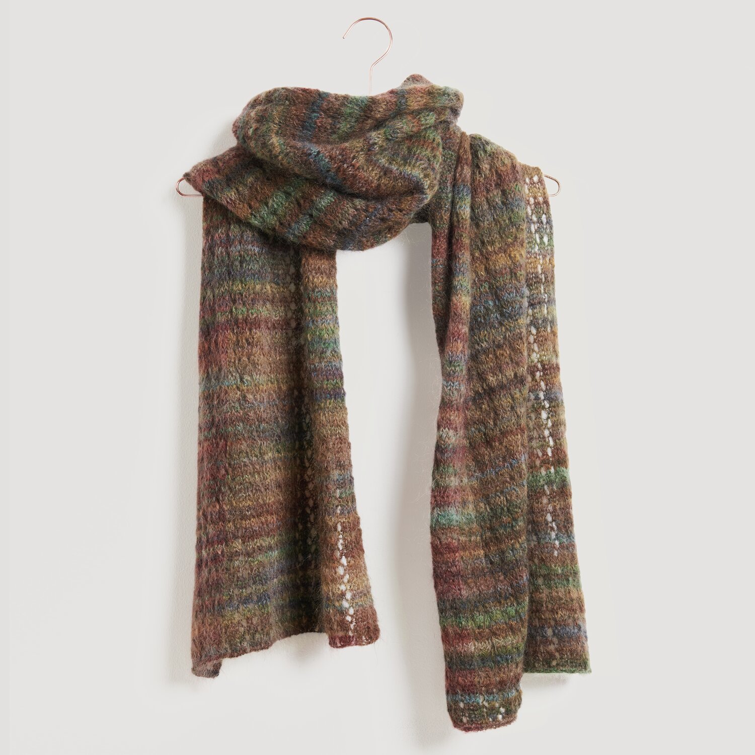 Lovewool No. 21 Herbst-Winter Sprachauswahl deutsch von Rico Design Ein gestrickter Schal in warmen Erdtönen, darunter Braun, Grün und Rot. Der Schal ist von der Marke Modell Legeware und bietet ein stilvolles, gemütliches Accessoire für kühle Tage.