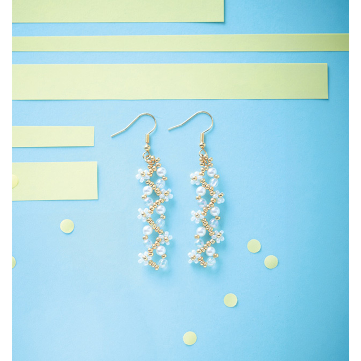 Schmuck aus Miniperlen, elegante Ohrringe mit weißen Perlen auf blauem Hintergrund. Ideal für stilvolle Anlässe.