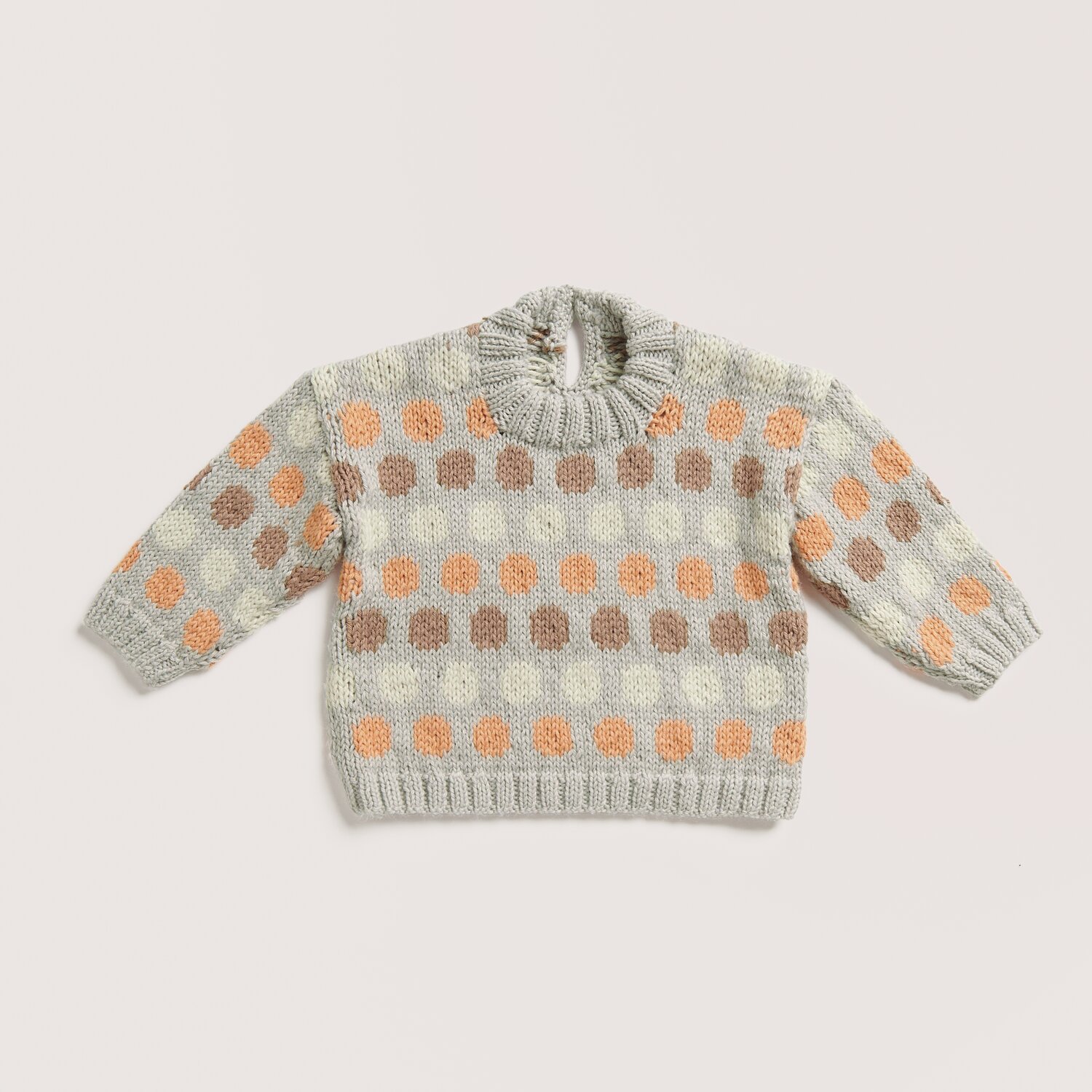 Rico Baby 042 Sprachauswahl deutsch von Rico Design Strickset Pullover Modell 05 aus Baby 042 in Silbergrau mit buntem Punktmuster aus Apricot und Nougat. Perfekt für stilvolle Kinderbekleidung.