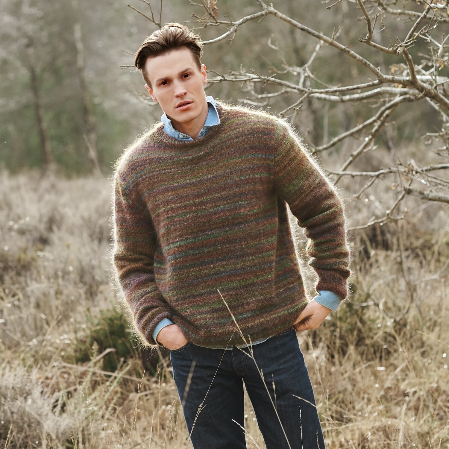 Strickset Pullover Herren Modell 09 aus Lovewool No. 21 von Rico Design Strickset Pullover Herren Modell 09 aus Lovewool No. 21, braun, getragen von einem Mann in natürlicher Umgebung.
