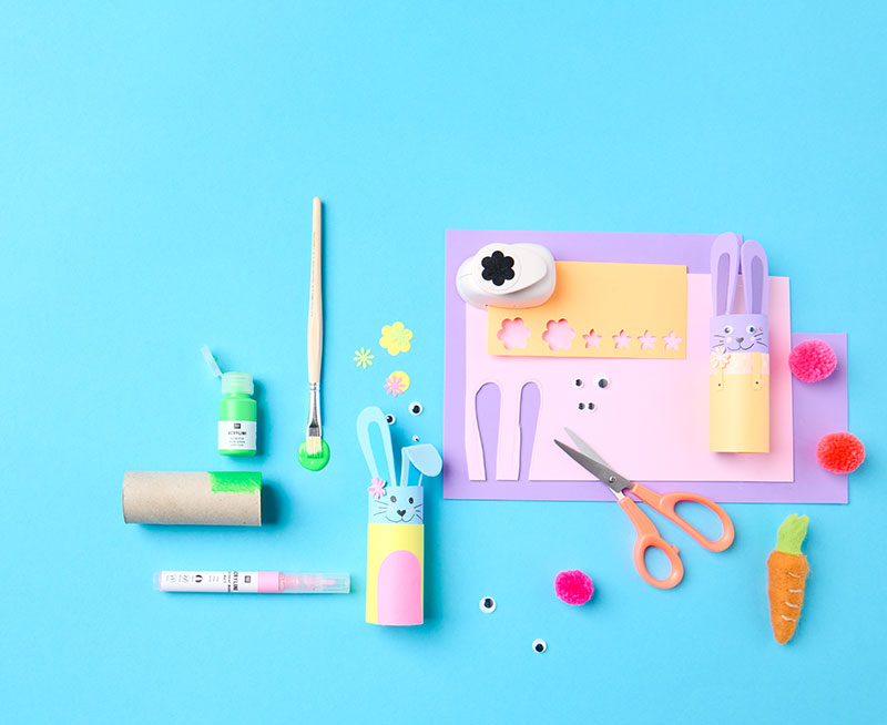 Bastelmaterial für Osterhasen aus Klopapierrollen und fertige Hasen