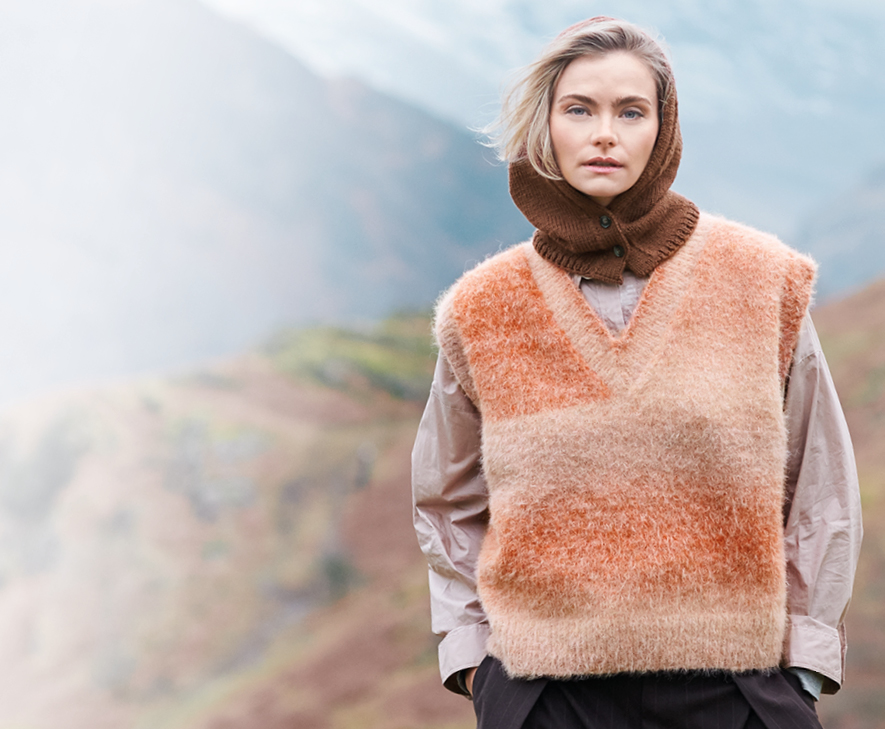 Model trägt gestrickten Pullunder und Kapuzenkragen