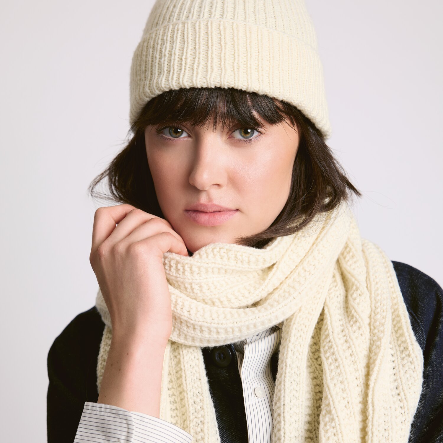 Strickset Mütze Modell 06 aus Luxury Knits - Premium Natural Fibres von Rico Design Strickset Mütze Modell 06 aus Luxury Knits - Premium Natural Fibres. Frau trägt cremefarbene Mütze und Schal.