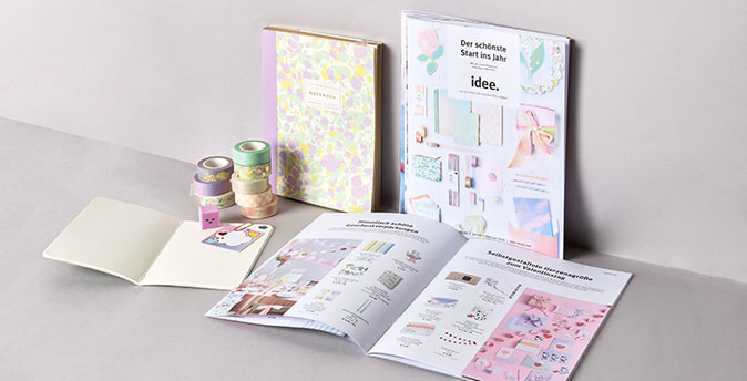 idee. Prospekt liegt in grauer Ecke mit Produkten daneben