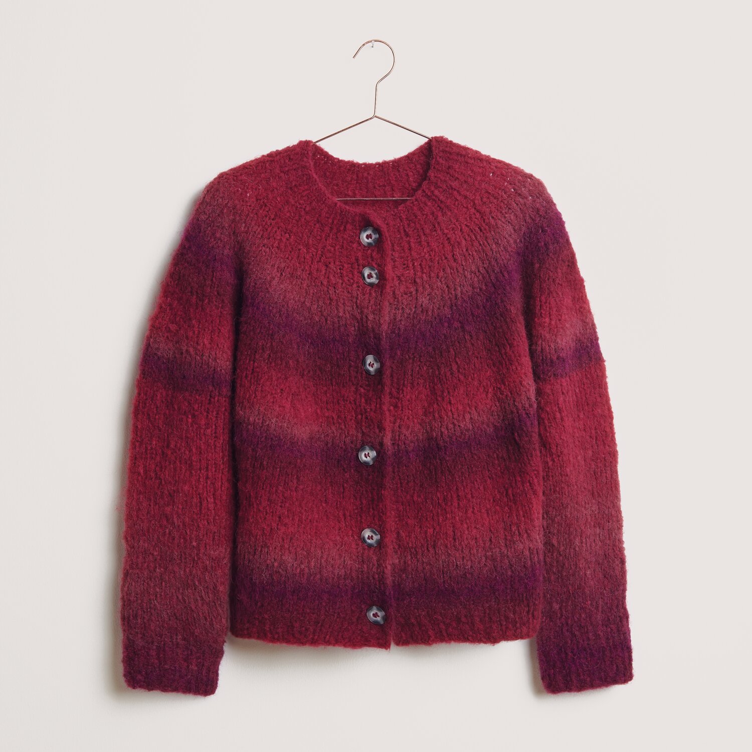 Die Neue Masche No. 14 Winter von idee. Creativmarkt Fashion Alpaca Superfine Heavens Big Cloud: Roter Strickpullover mit Knöpfen, aus weicher Wolle, hängend an einem Kleiderbügel.