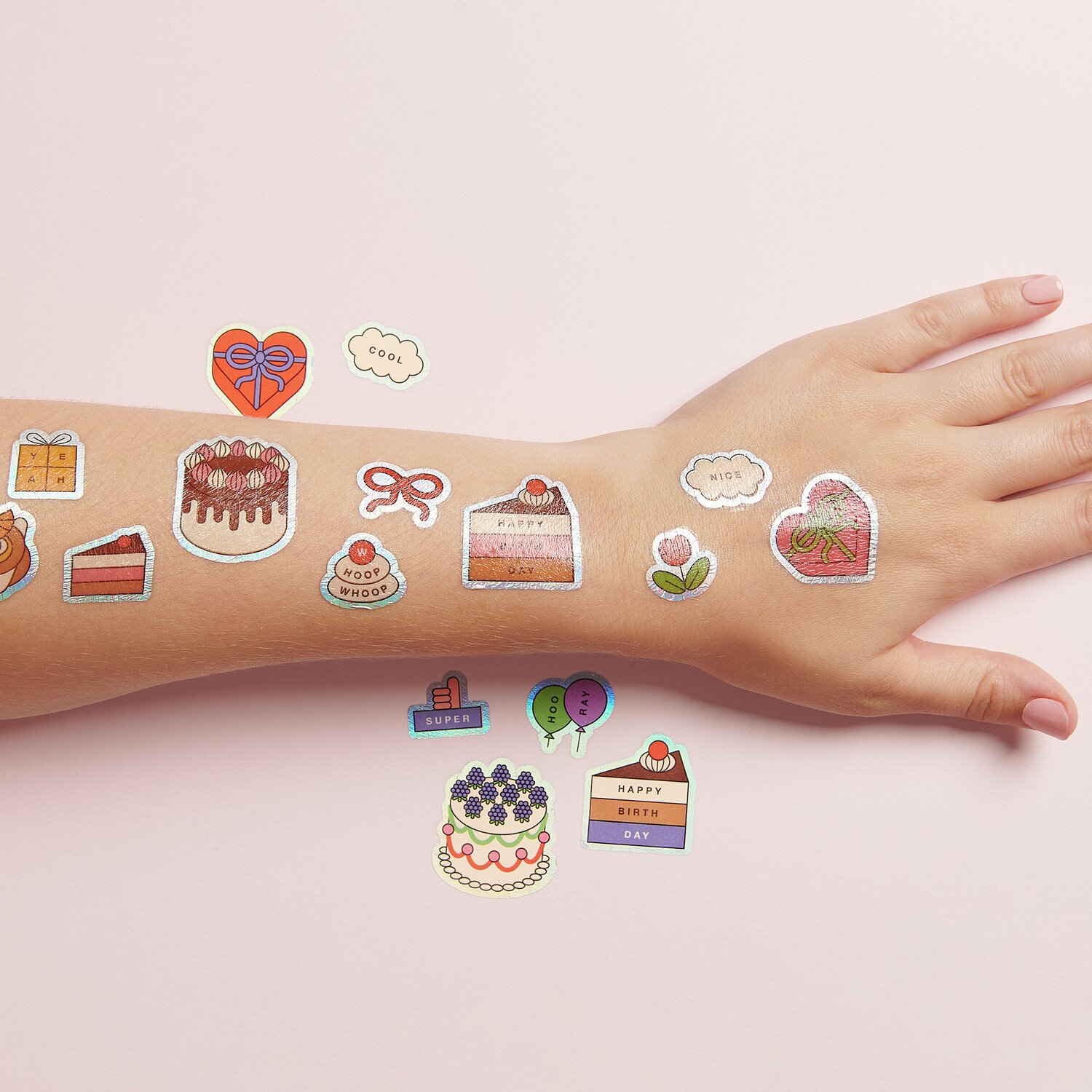 Tattoos Eye Candy, 16-teilig: Bunte temporäre Tattoos mit Kuchenmotiven auf einem Arm, ideal für Partys.