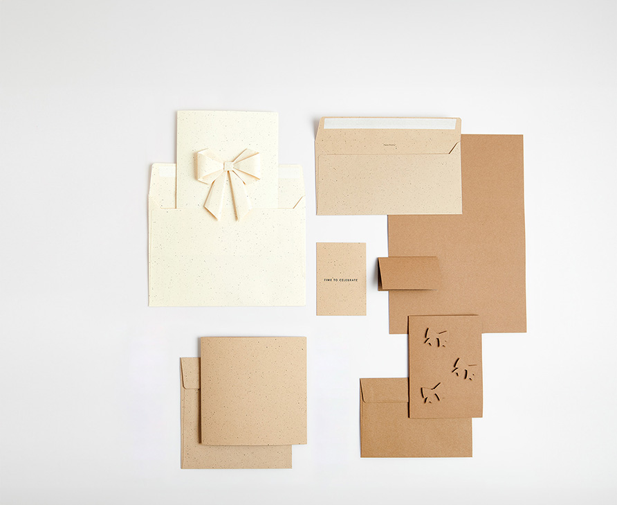 Kraftpapier Karten, teilweise mit Schleifen, und Umschläge übereinandergelegt. Flatlay von Produkten. 