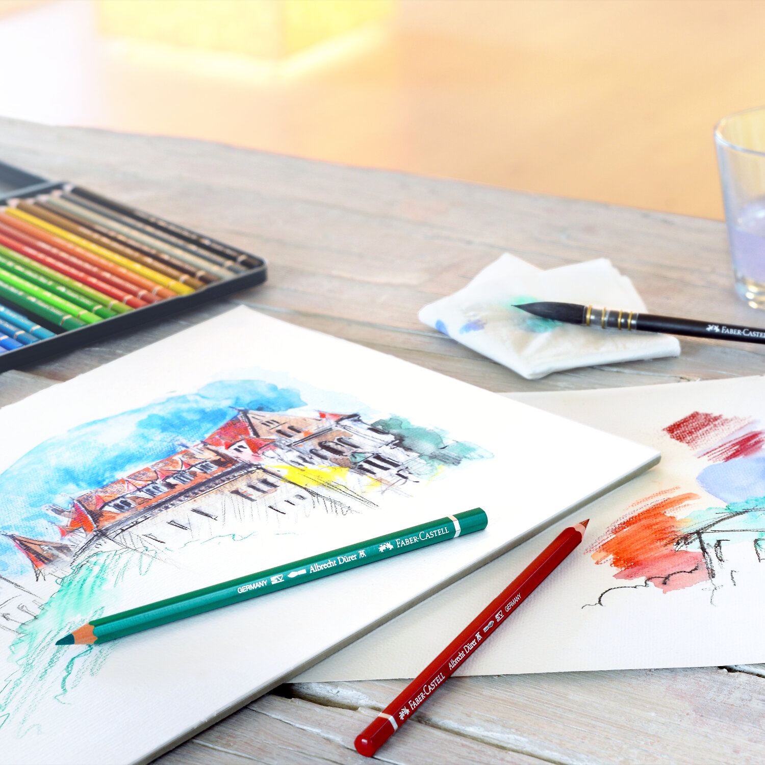 Albrecht Dürer Aquarellstift von Faber Castell auf einem Tisch mit Skizzen und weiteren Stiften.