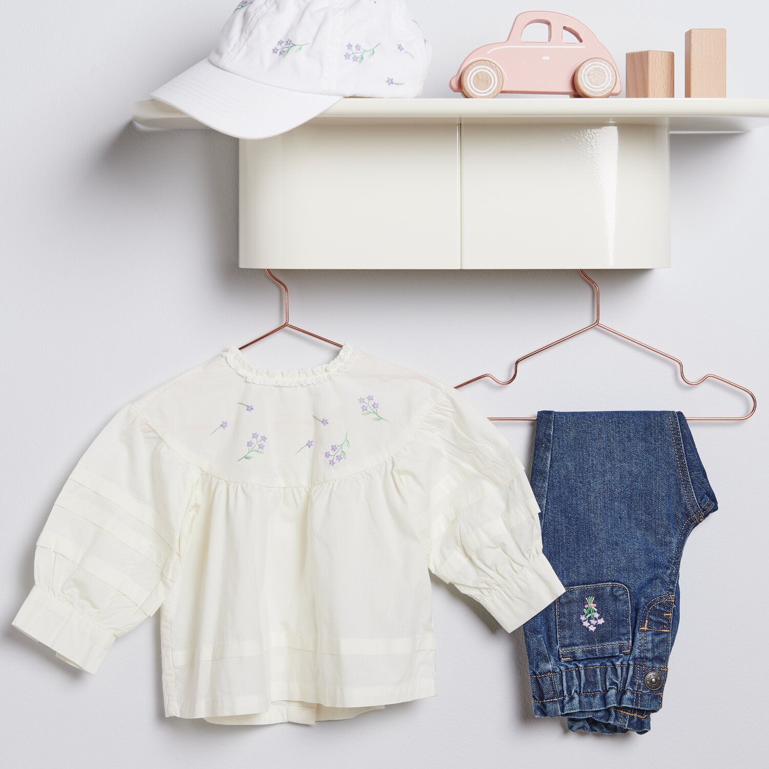 Stick & Stitch Packung Blumenkränze XL 13 Stück: Weiße Bluse und Jeans für Kinder, dekorativ arrangiert mit Mütze und Spielzeugauto.