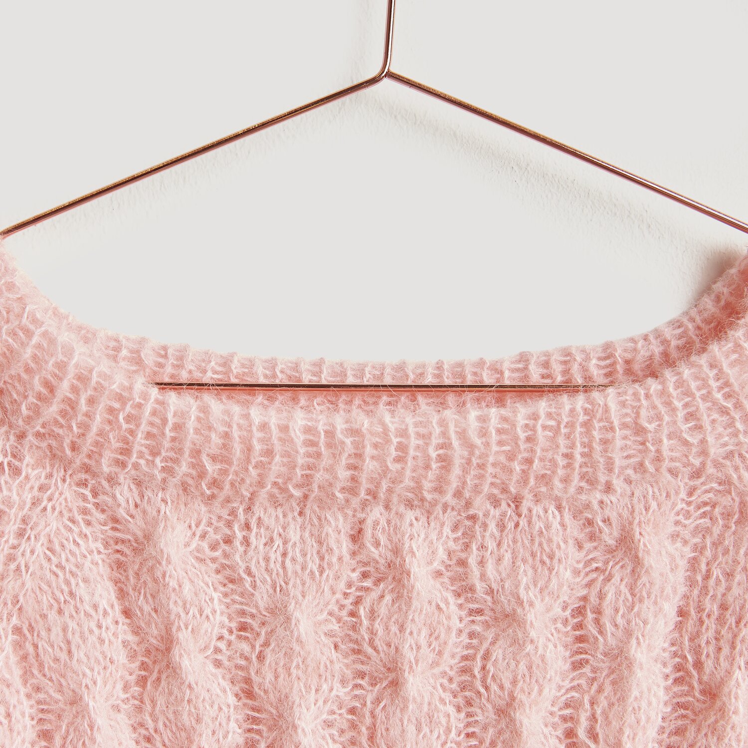 Die Neue Masche No. 13 Herbst von idee. Creativmarkt Luxury Alpaca Cotton Fusion Pullover in Apricot auf einem Kupferbügel, gestrickt mit Zopfmuster.
