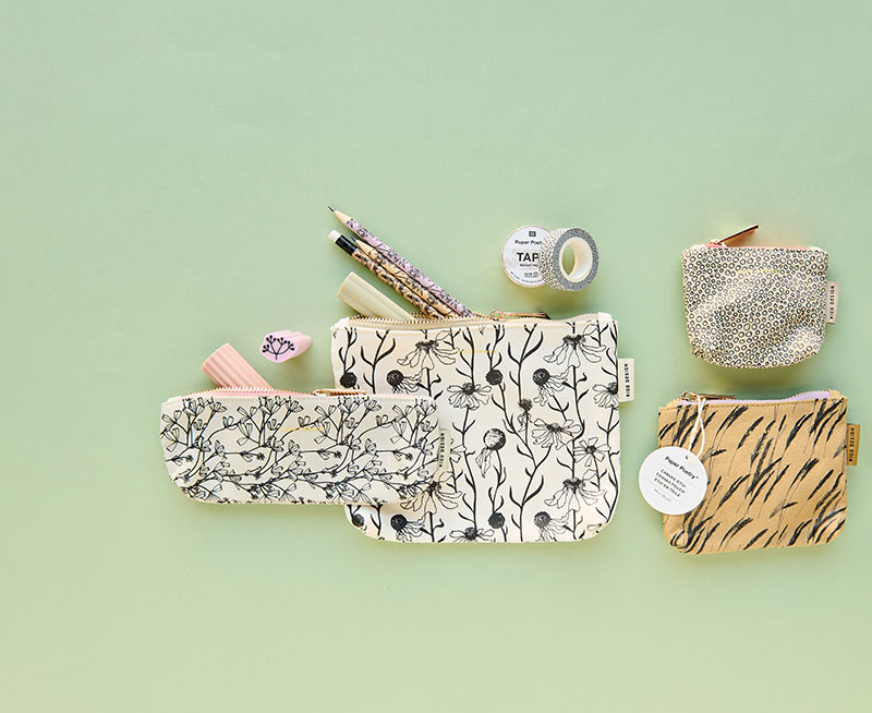 Vier unterschiedliche Etuis mit Bleistiften, Washi Tape und Radiergummis. Flatlay von Produkten aus der Kollektion In The Meadow.