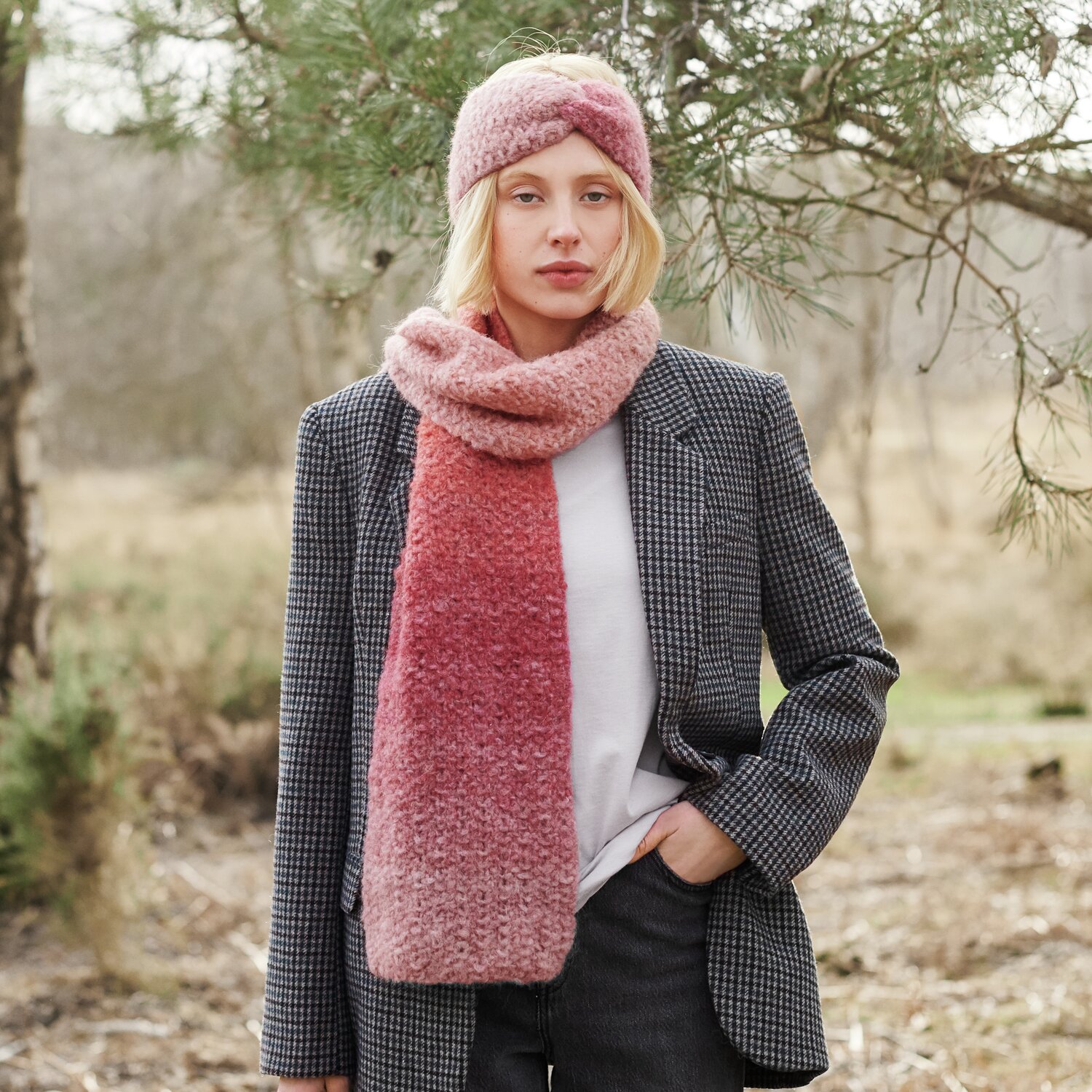 Strickset Stirnband + Schal Modell 34 aus Lovewool No. 21 von Rico Design Strickset Stirnband + Schal Modell 34 aus Lovewool No. 21 in Rosa, getragen von Frau im Freien.