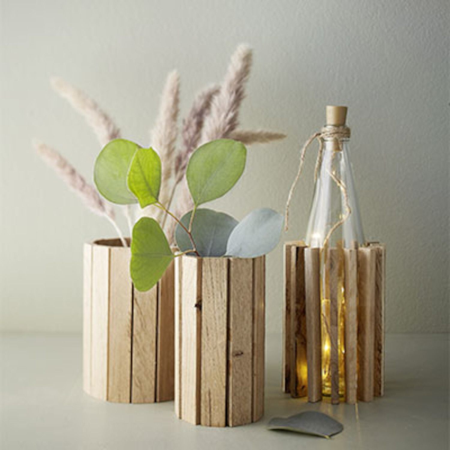 Klötzchenfieber! Holzvasen-Set mit Trockenblumen und Lichterflasche auf hellem Tisch.