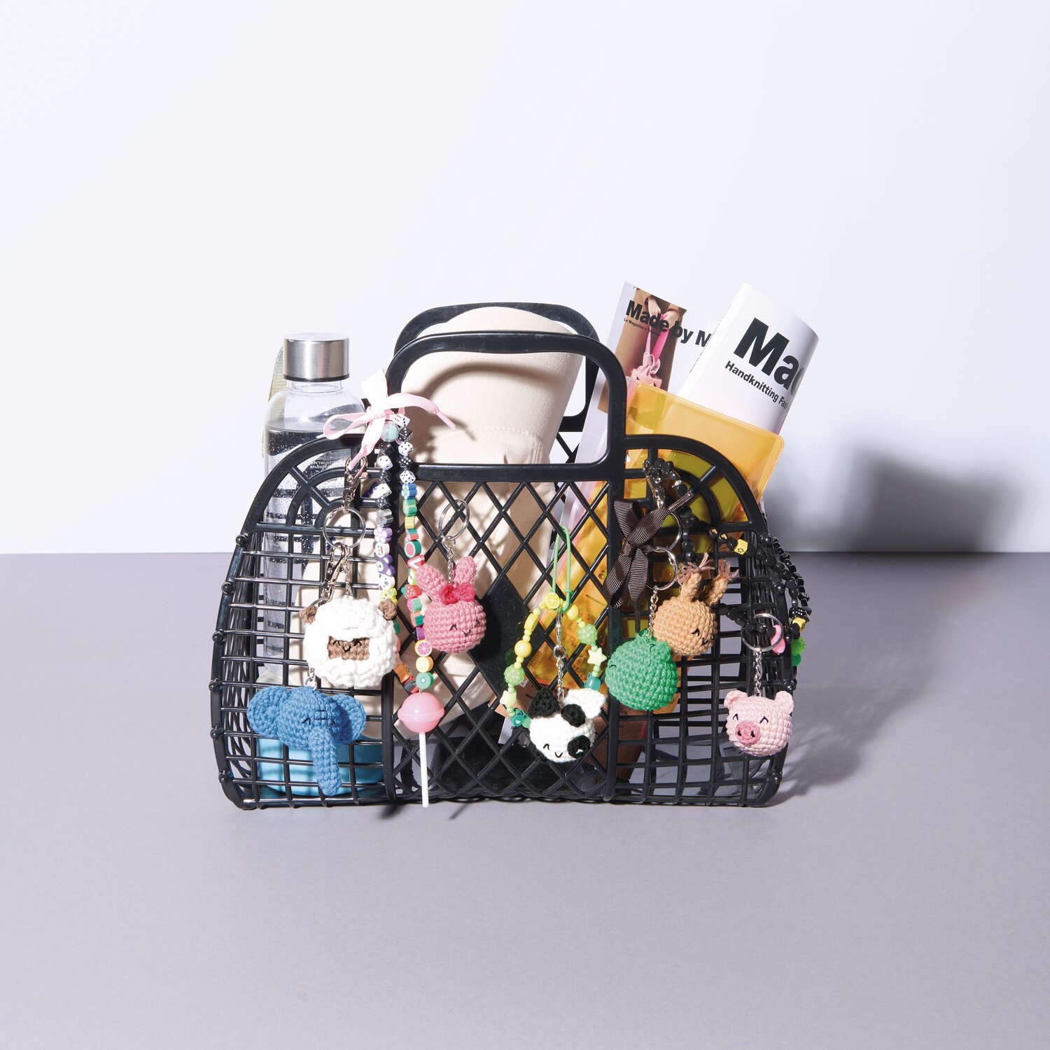 Ricorumi Rico Chingus: Schwarze Tasche mit bunten Anhängern und Magazinen, ideal für kreative Aufbewahrung.