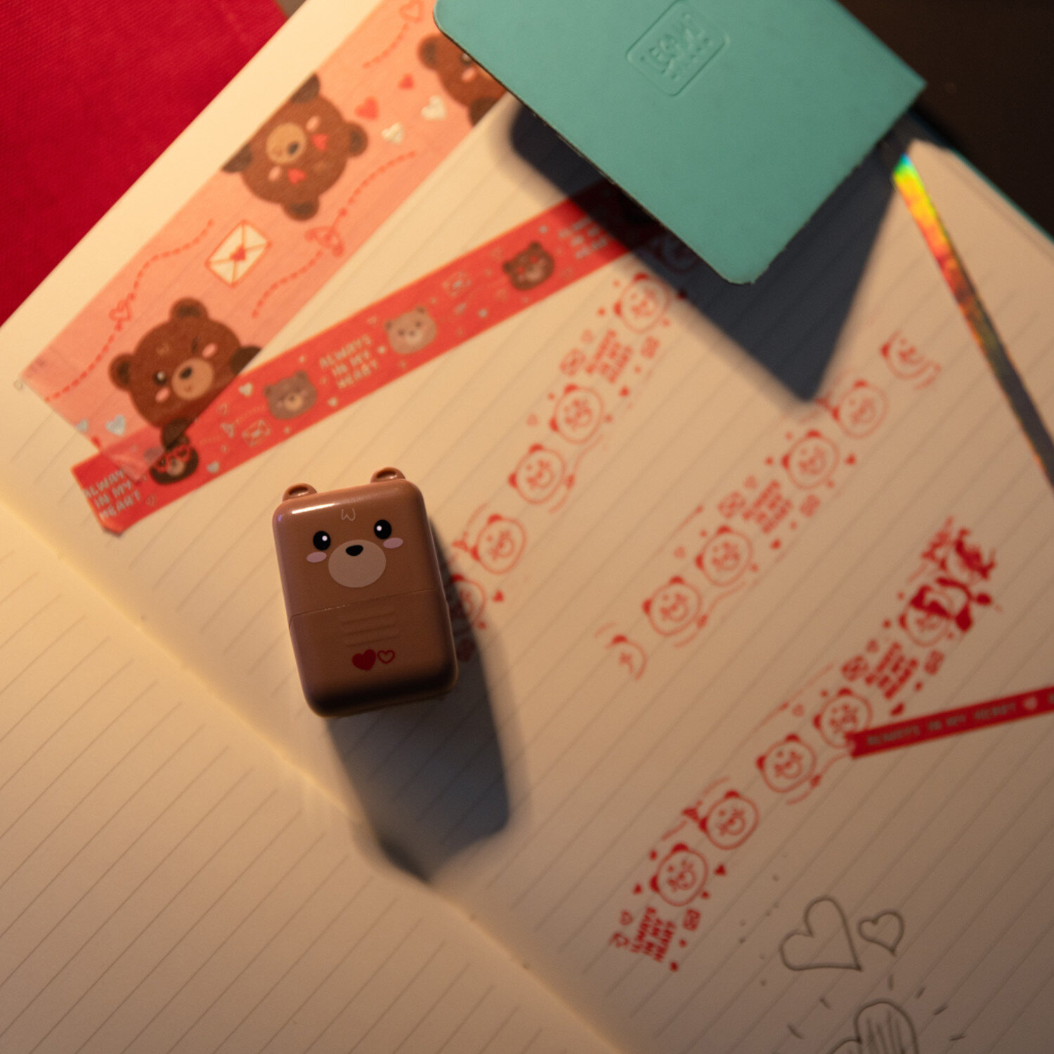 Deco Roller Stempel von Legami auf aufgeschlagenem Notizbuch, zeigt verspielte Bärchen‑Muster und rote Deko-Streifen für kreatives Planen und Journaling