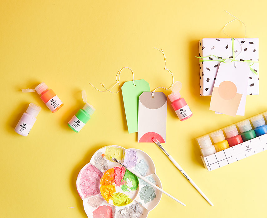 kleine Acrylfarbentuben und bemalte Geschenkanhänger
