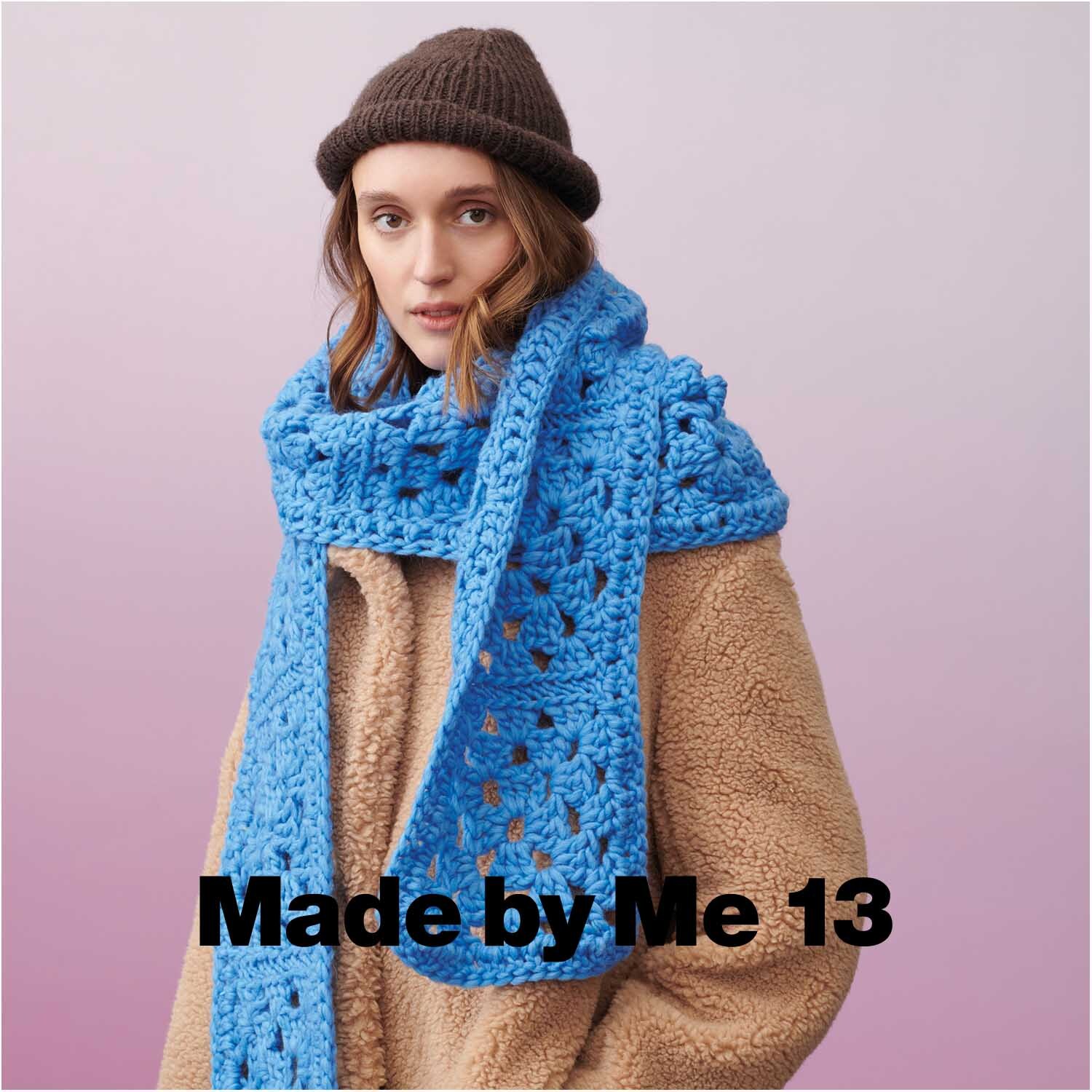 Essentials Super super chunky: Frau trägt blauen, grob gestrickten Schal von Rico Design, kombiniert mit braunem Mantel und Mütze.