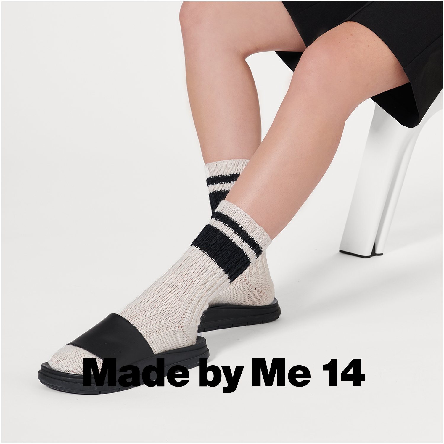 Superba Bamboo Uni 4fädig: Person trägt cremefarbene Socken mit schwarzen Streifen und Sandalen.