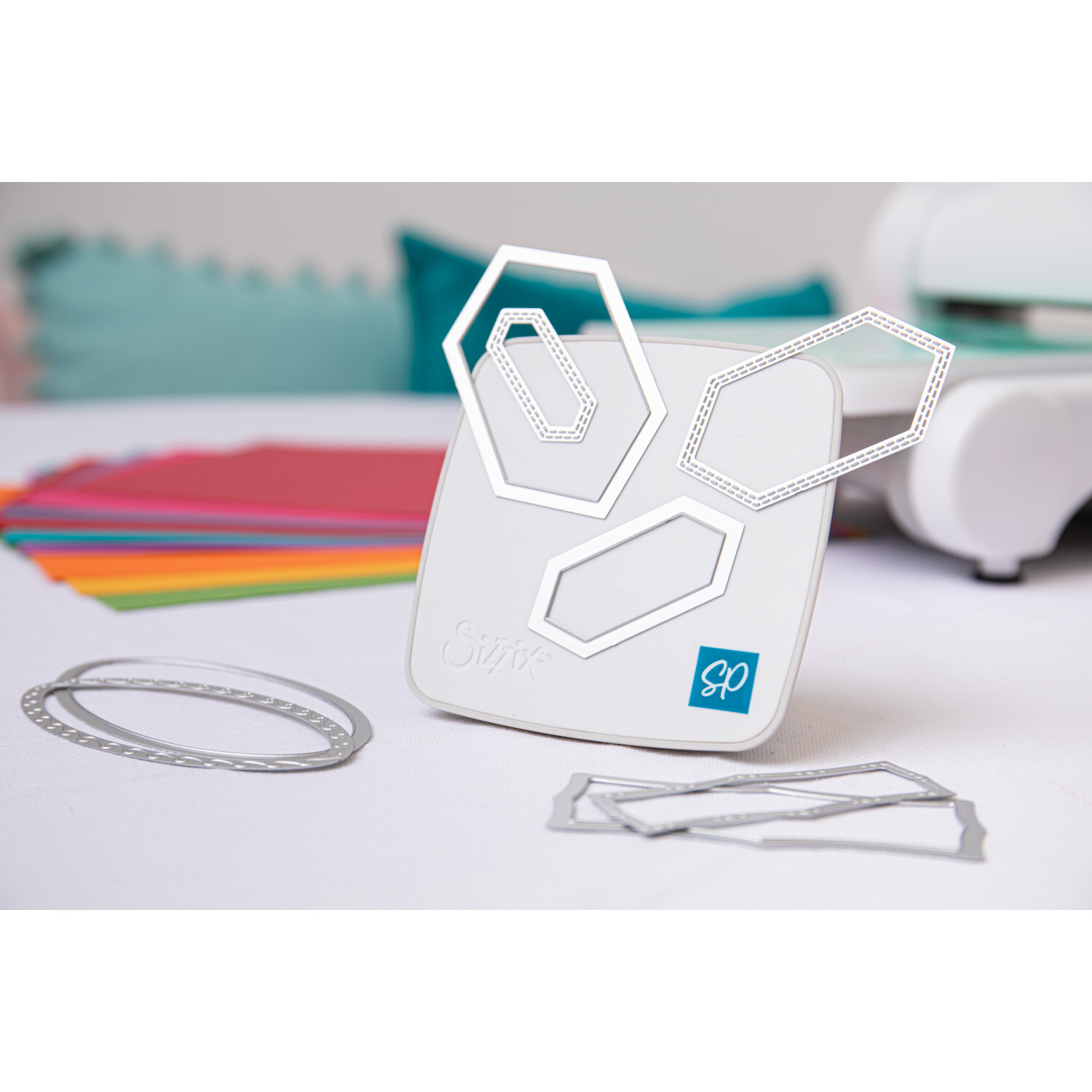 Making Tool Gotcha Magnetic Craft Stand von idee. Creativmarkt Making Tool Gotcha Magnetic Craft Stand in Weiß mit geometrischen Formen, ideal für Bastelprojekte. Im Hintergrund bunte Papiere und ein Schneidegerät.