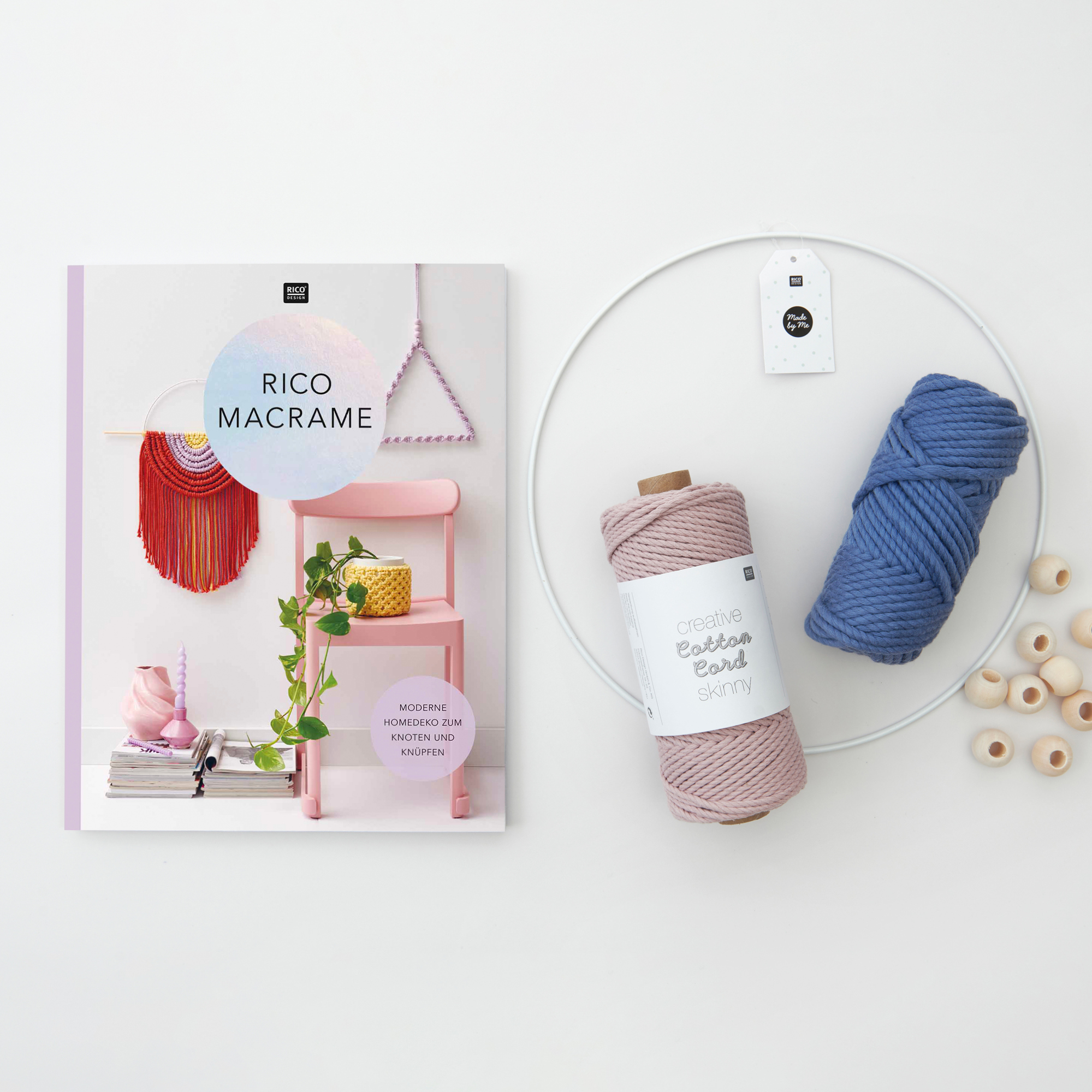 Rico-Macrame-Heft daneben ein Ring und zwei unterschiedliche Kordel-Garne und Holzperlen. Flatlay von Produkten.