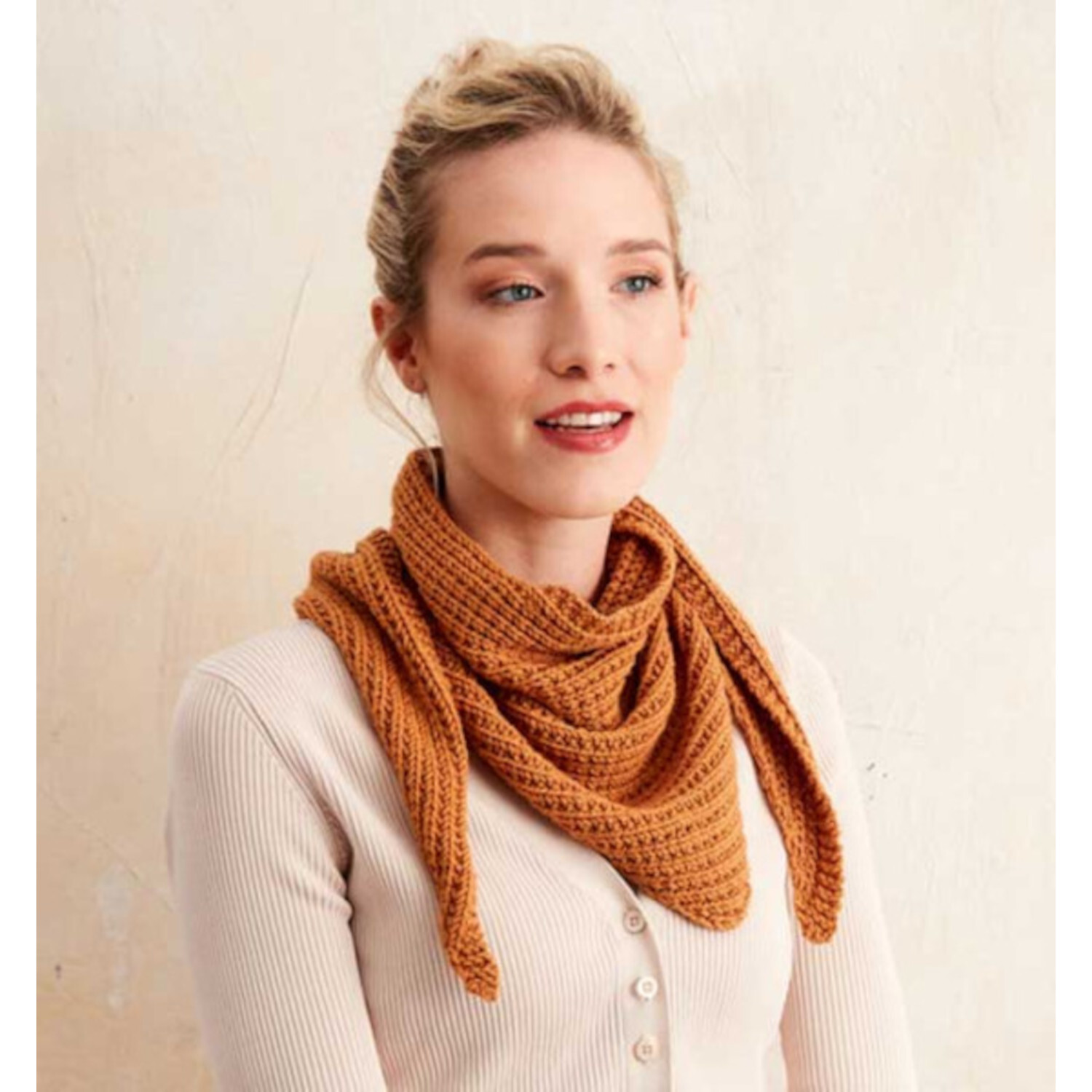 Stricken mit Struktur: Frau trägt gestrickten, orangefarbenen Schal. Elegantes Design von TOPP.