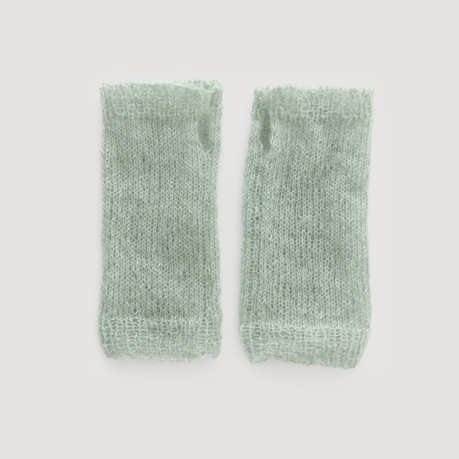 Lovewool No. 21 Herbst-Winter Sprachauswahl deutsch von Rico Design Paar hellgrüne Strickstulpen von Modell Legeware, nebeneinander auf hellem Hintergrund. Ideal für kühle Tage, bieten sie Komfort und Stil. Perfekt für modische Akzente.