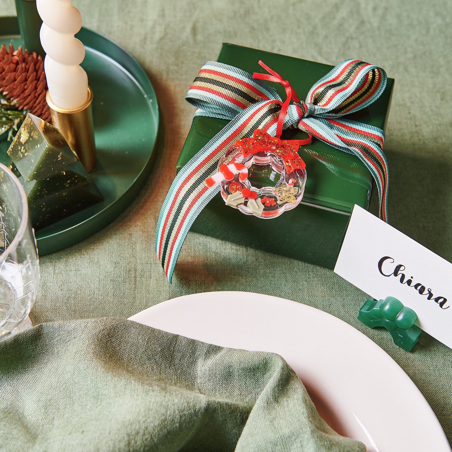 Silikon Gießform Mini-Weihnachtskranz auf grünem Geschenk mit rot-grünem Band dekoriert.