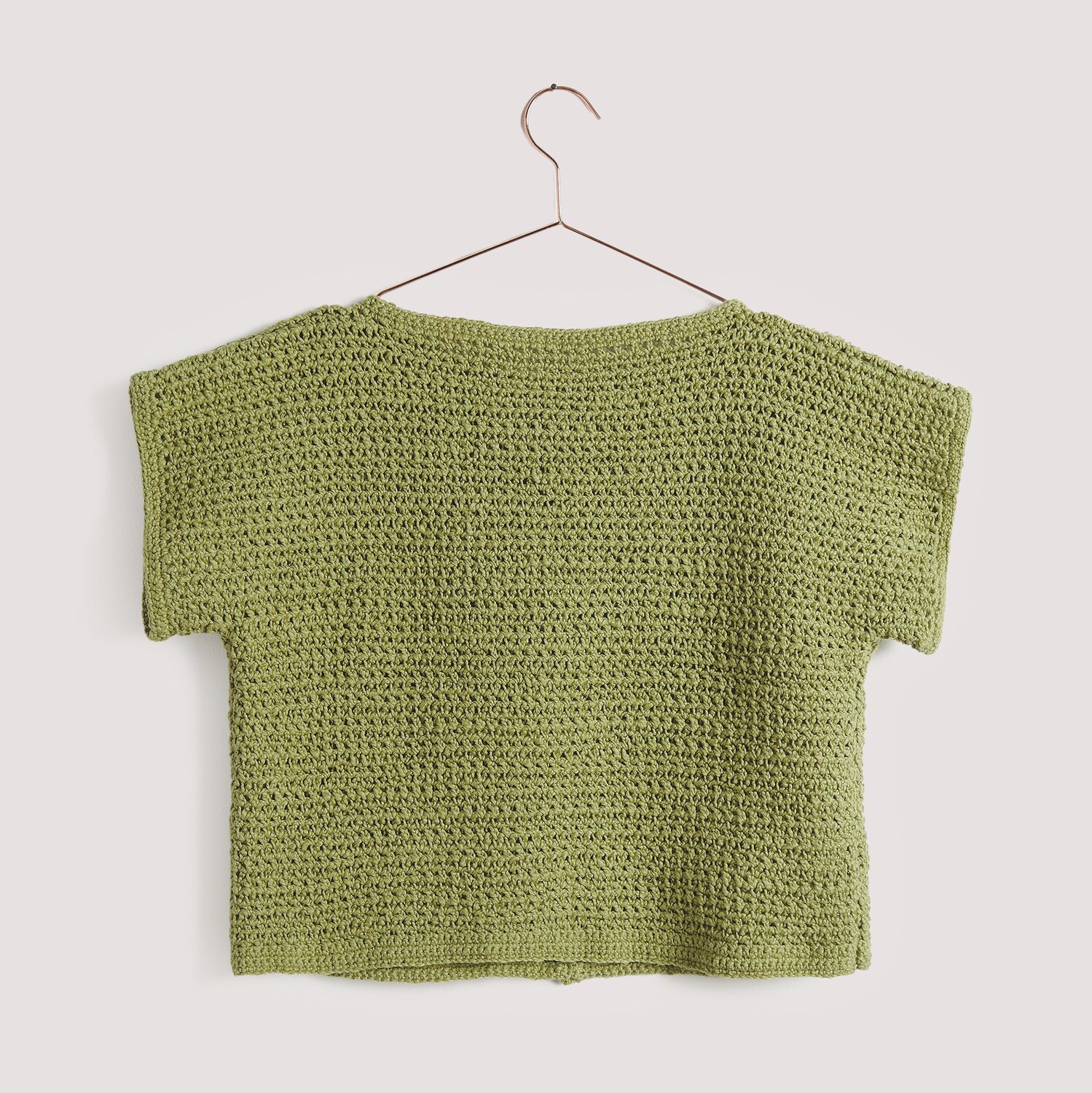 Essentials Super Cotton dk: Olivgrüner, handgestrickter Pullover auf einem Kleiderbügel, präsentiert von Rico Design.