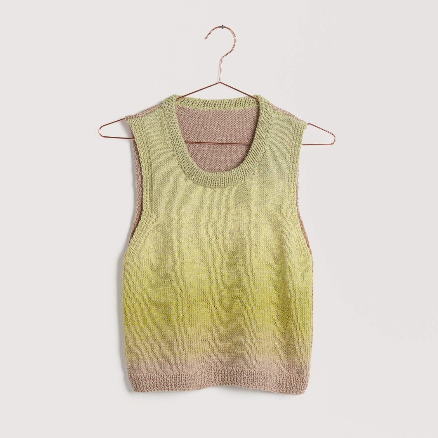 Strickset Top Modell 08 aus Lovewool No. 22, ärmelloses Oberteil in sanften Gelb- und Beigetönen, aufgehängt an einem Kleiderbügel.