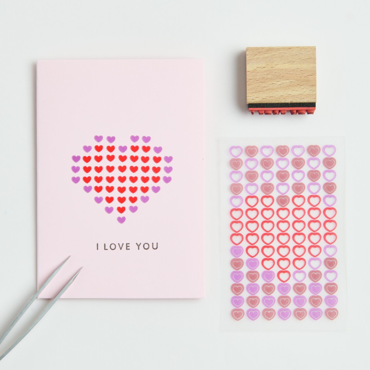 Mini-Foliensticker Herzen 3 Bögen: Rosa Karte mit Herzstickern in Rot und Rosa, daneben ein Holzstempel.