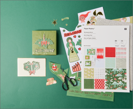 Weihnachtsgeschenke und Karte aus Motivpapierblock auf grünem Hintergrund.