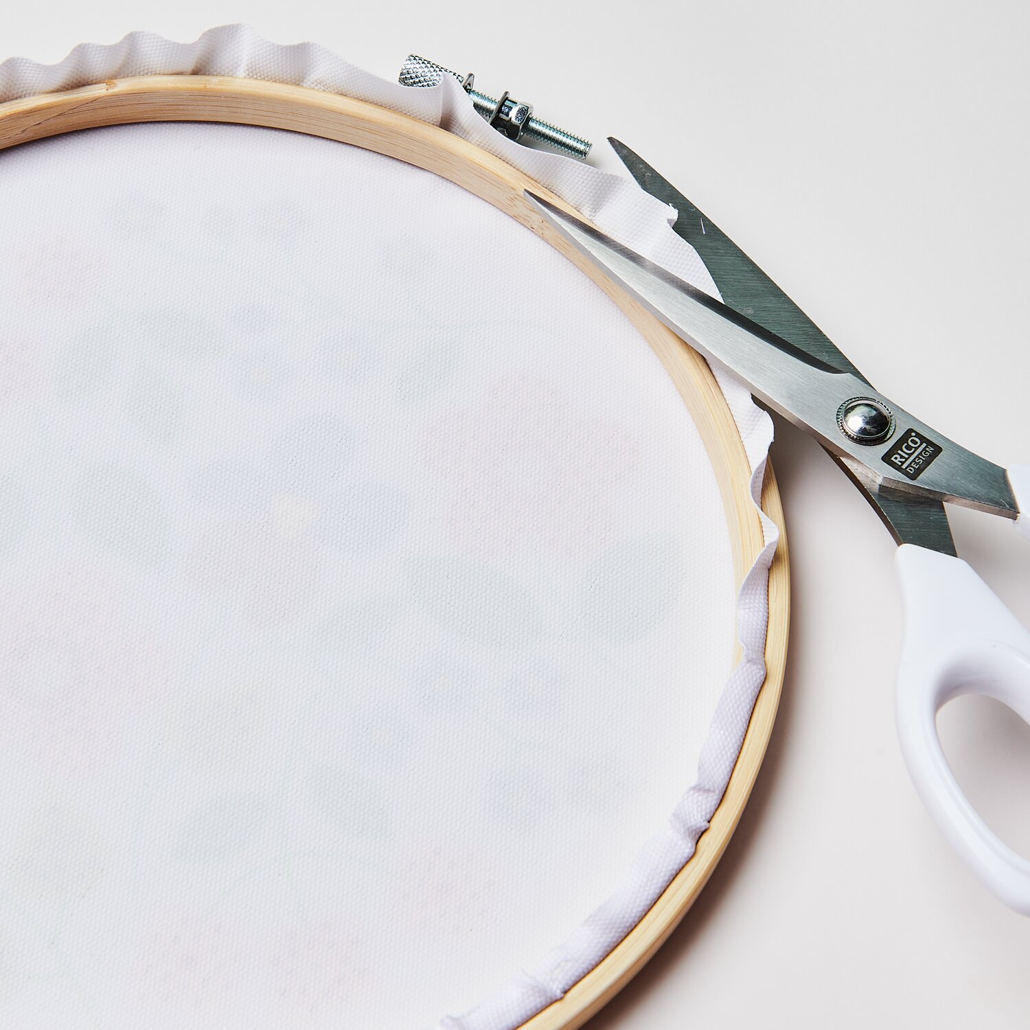 Diamond Painting DIY-Set Schimmernde Blumen, 19-teilig, zeigt einen Stickrahmen mit Schere.