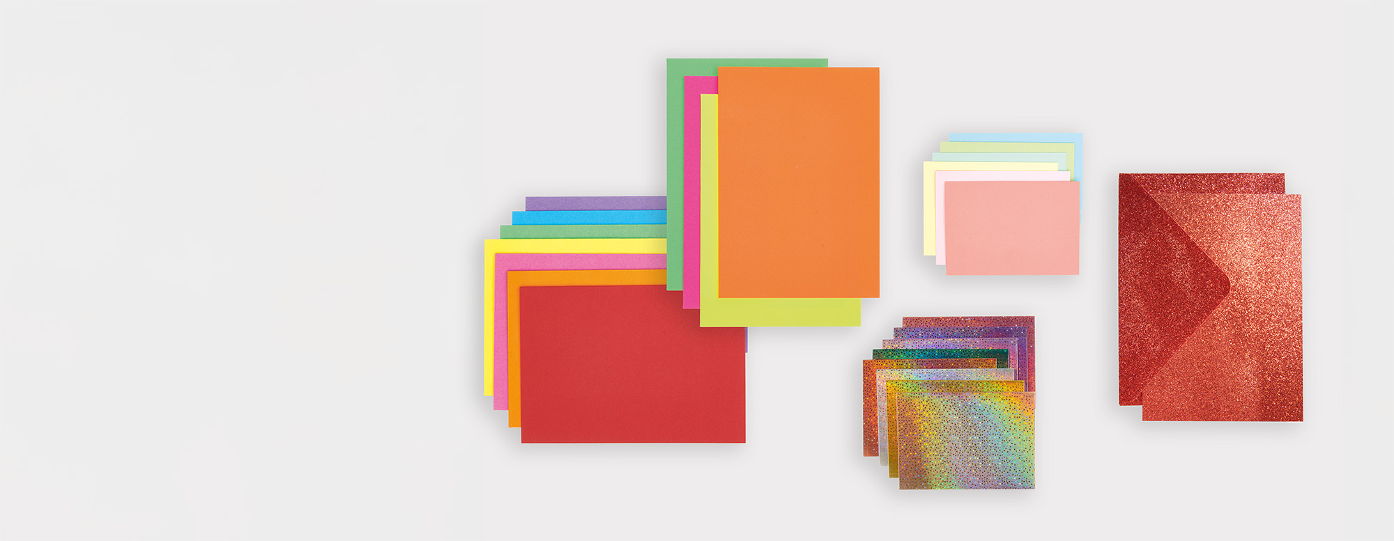 Fünf bunte Kartenstapel in verschiedenen Größen und Farbvarianten. Flatlay von Produkten.