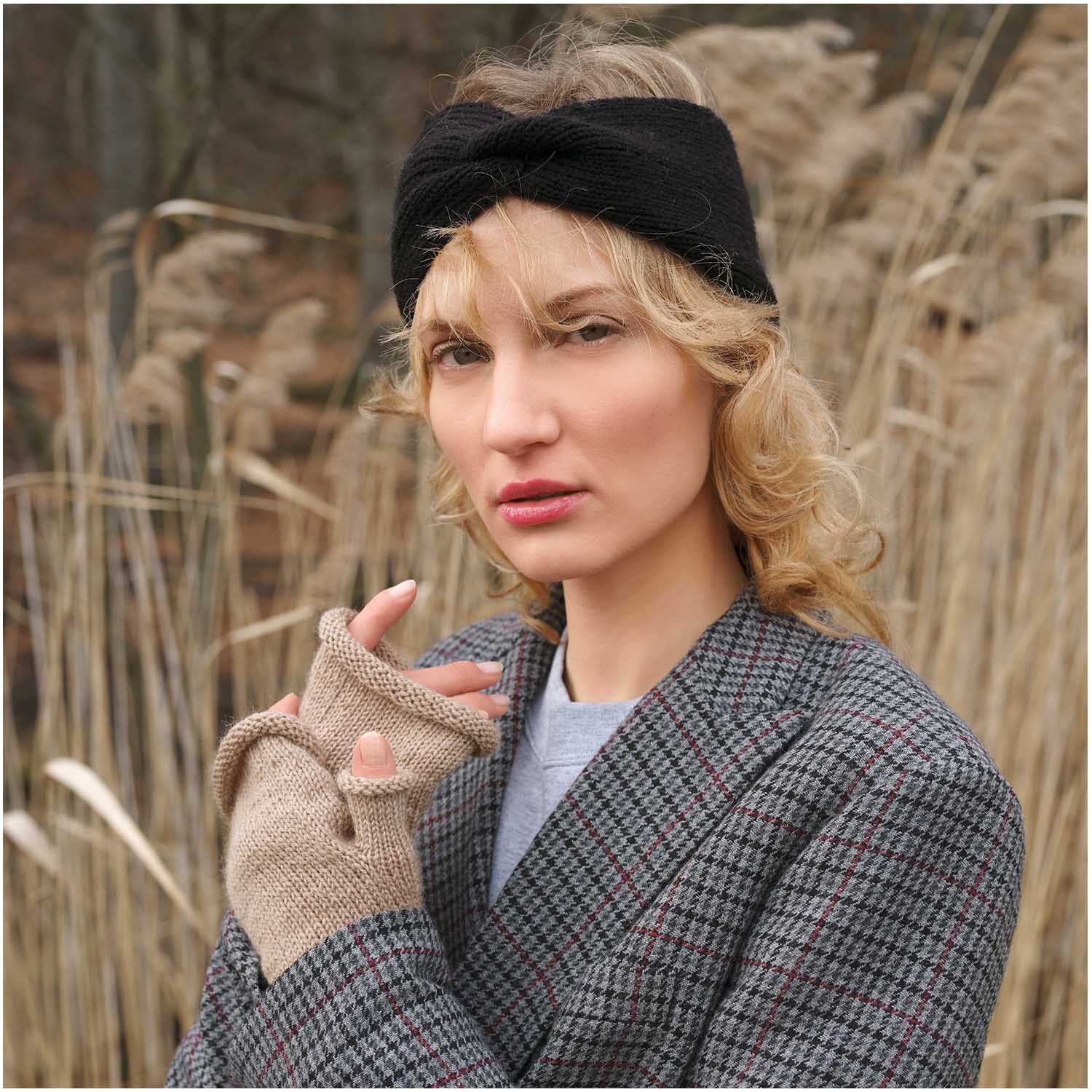 Essentials Fine Fine Merino: Frau mit schwarzem Stirnband und beige melierten Handschuhen in natürlicher Umgebung.