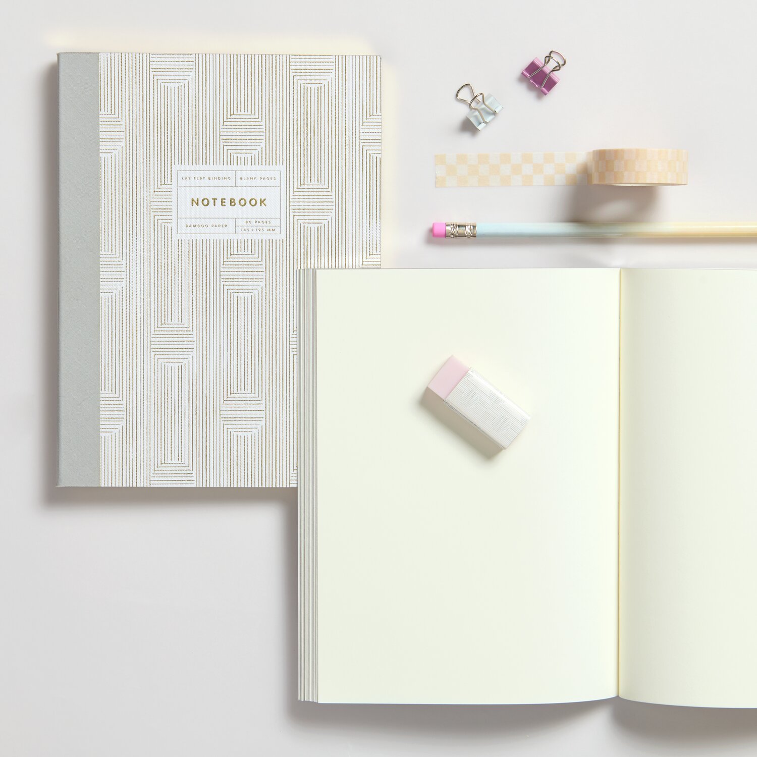 Notizbuch S Struktur 80 Seiten mit grauem Muster, offen liegend, neben Bleistift und Radiergummi.