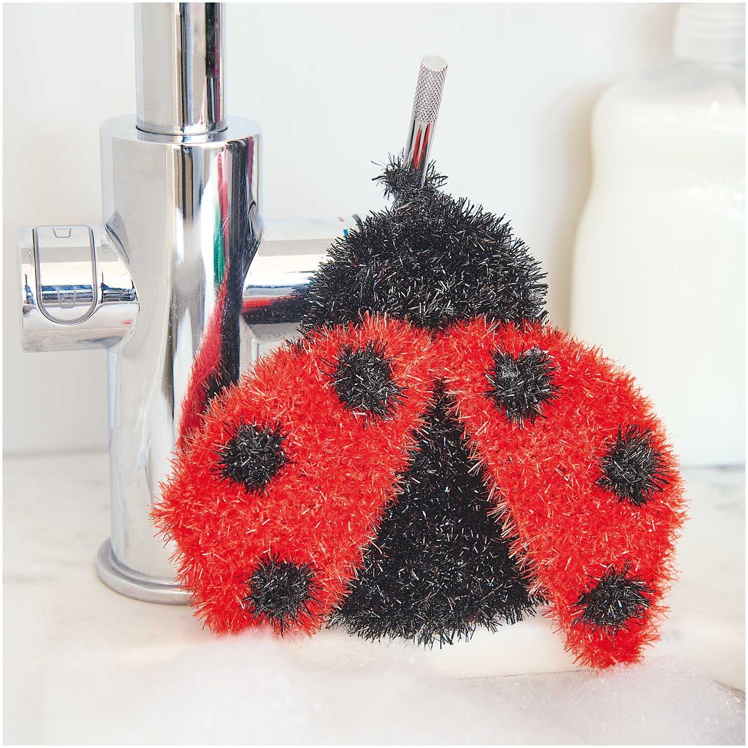 Creative Bubble: Ein roter Marienkäfer-Schwamm von Rico Design neben einem Wasserhahn. Ideal für kreative Reinigungsprojekte.