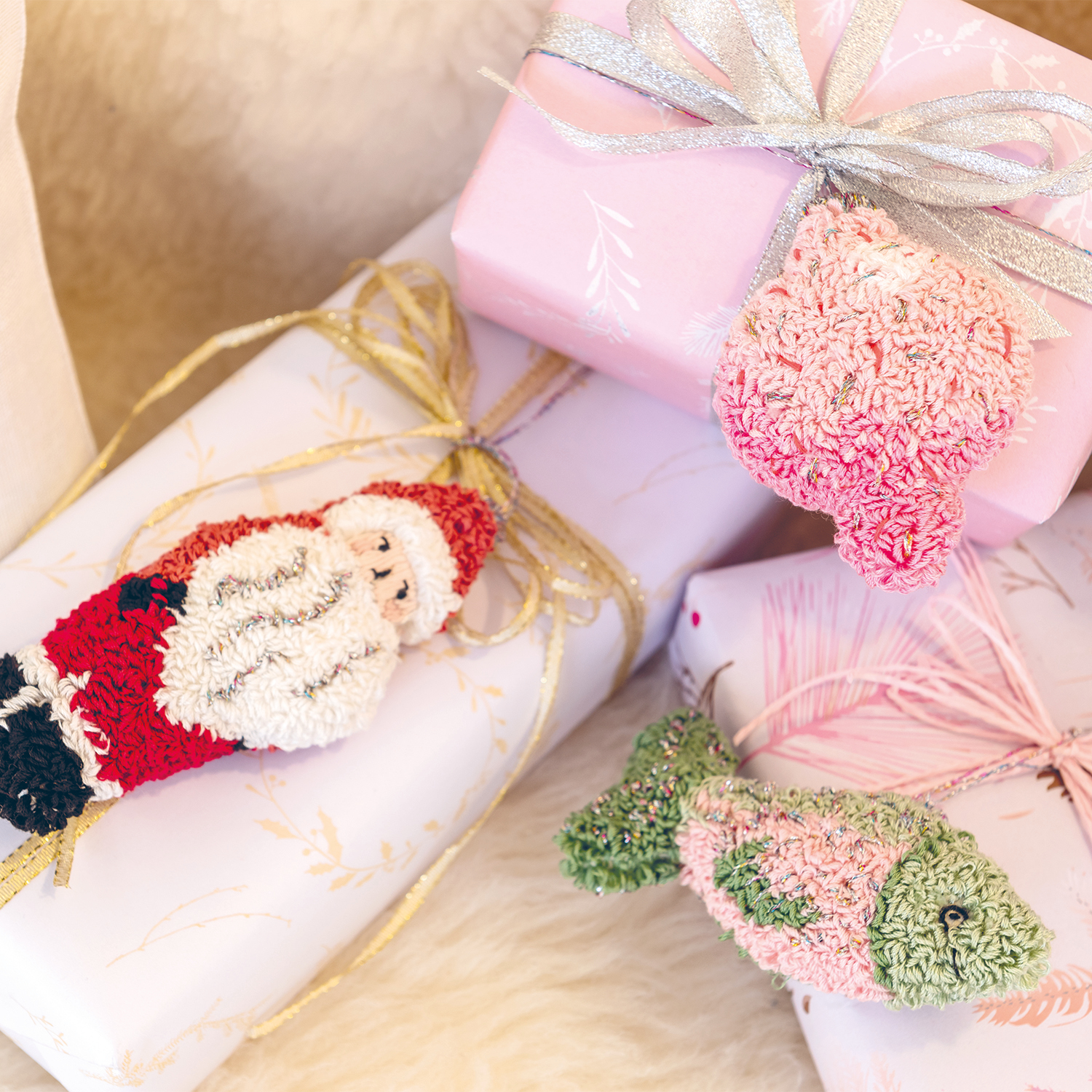 Anleitung Weihnachtliche Punch Needle Anhänger: Handgemachte Anhänger in Rot, Grün und Rosa auf Geschenken.