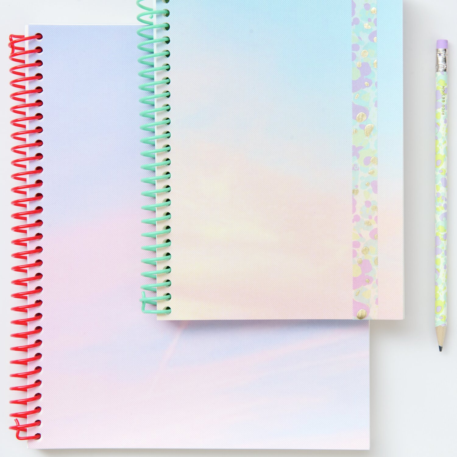 Notizbuch S Himmel 80 Seiten mit pastellfarbenem Cover und roter Spirale, daneben ein florales Bleistiftset.