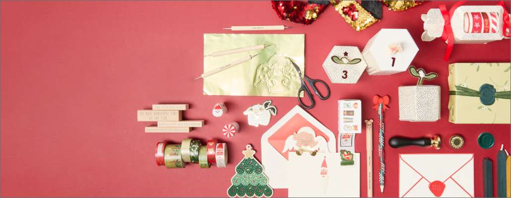 Kreativmaterialien für weihnachtliche Karten, Geschenke und Dekorationen auf rotem hintergrund.