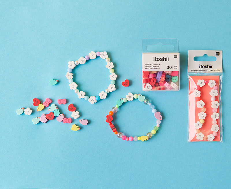 Drei Armbänder aus und mit verspielten Perlen in Wolken-, Vogel- und Herzform. Flatlay von produkten der Kollektion Rico Chingus.