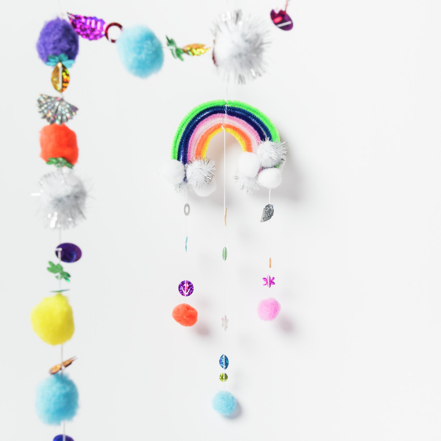 DIY-Bastelset Regenbogen: Mehrfarbige Hängedeko mit Pompons und Glitzer von Rico Design, ca. 100-teilig.
