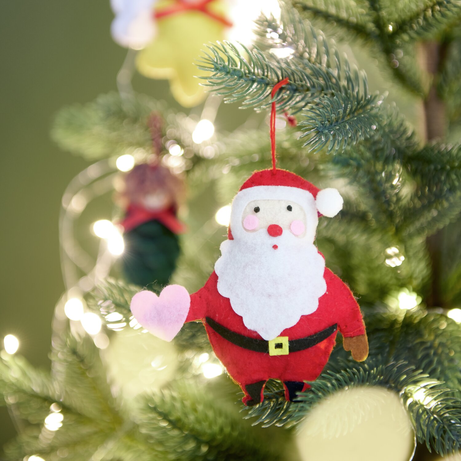 Aufhänger Filz-Weihnachtsmann mit Herz Rot/Weiß: Handgefertigter Weihnachtsbaumschmuck aus Filz, verleiht festliche Stimmung.