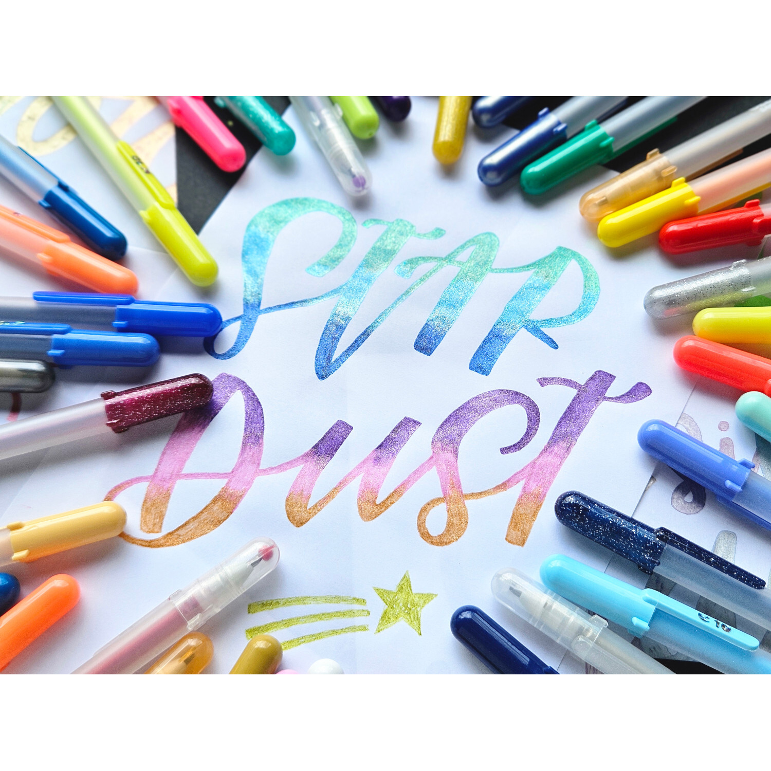Gelly Roll Stardust Glitter Gelstifte Set 12 Stück von Royal Talens Gelly Roll Stardust Glitter Gelstifte Set 12 Stück in bunten Farben, arrangiert um den Schriftzug "Star Dust". Ideal für kreative Projekte.