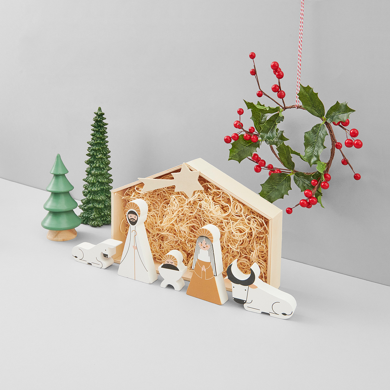 Krippe aus Holz mit Holzfiguren. Fotosetting graue Ecke.
